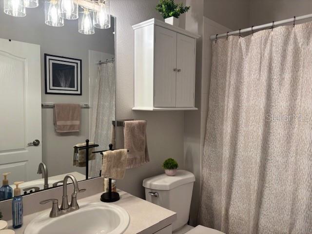 8623 Snowy Owl Way, Tampa, FL 33647 - bathroom featuring a notable chandelier, vanity, and toilet