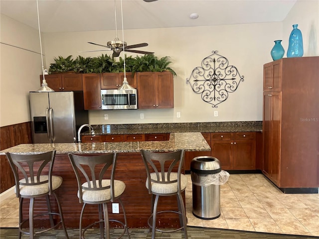 8623 Snowy Owl Way, Tampa, FL 33647 - kitchen with stainless steel appliances, light tile patterned floors, a kitchen bar, and ceiling fan