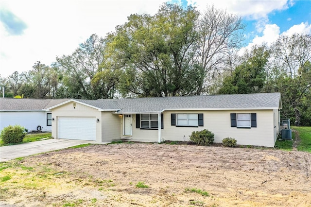 ranch-style house with a garage and central AC unit