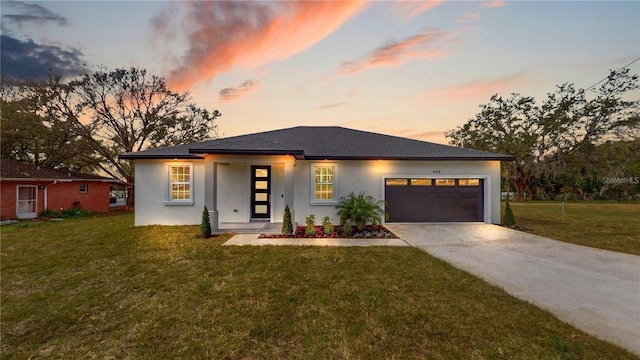 prairie-style home with a garage and a yard