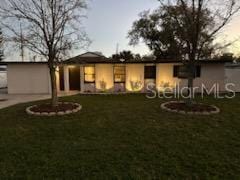 rear view of property featuring a lawn and driveway