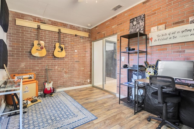 office space featuring light hardwood / wood-style floors and brick wall