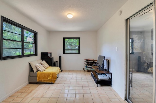 living area with light tile patterned floors and a textured ceiling