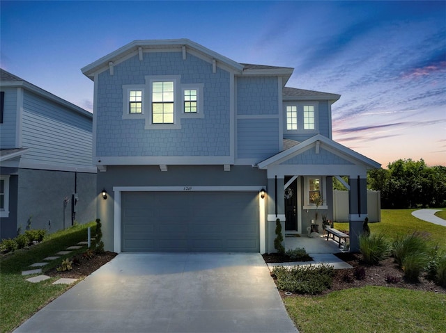 view of front of property with concrete driveway, an attached garage, and stucco siding