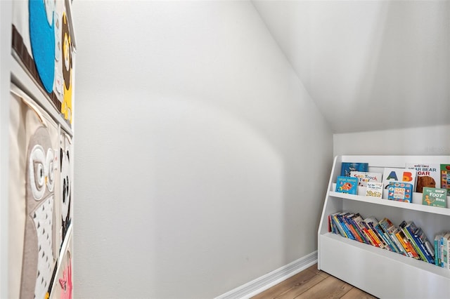 playroom with vaulted ceiling, wood finished floors, and baseboards