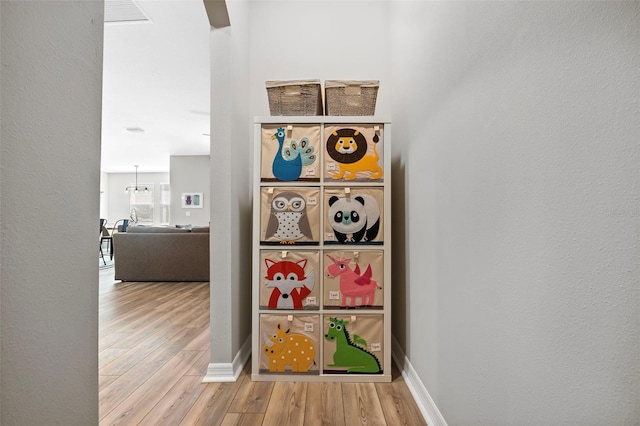 interior space with visible vents, baseboards, wood finished floors, and a textured wall