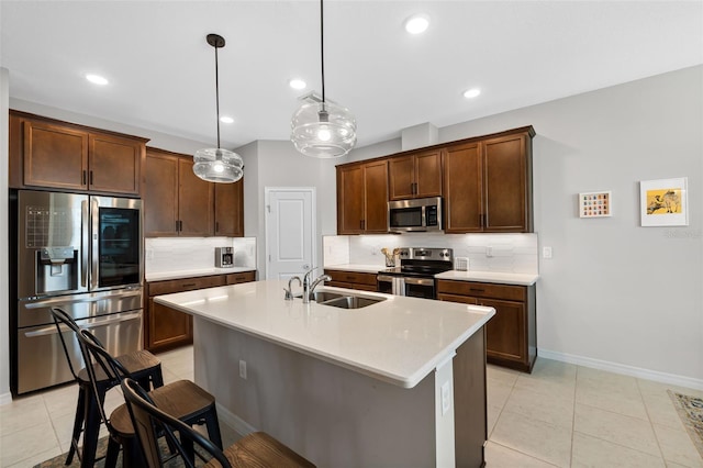 kitchen featuring backsplash, appliances with stainless steel finishes, light countertops, and a sink