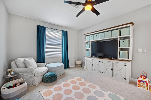 living area featuring carpet flooring, ceiling fan, and baseboards