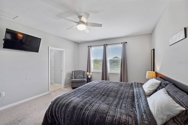 bedroom with a textured ceiling, carpet, baseboards, attic access, and ceiling fan