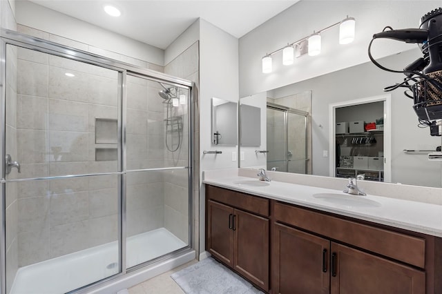 full bath featuring a sink, double vanity, and a shower stall