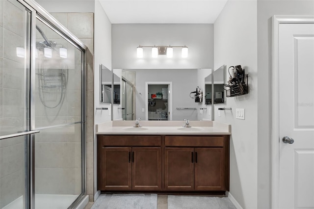 full bathroom with double vanity, a shower stall, and a sink