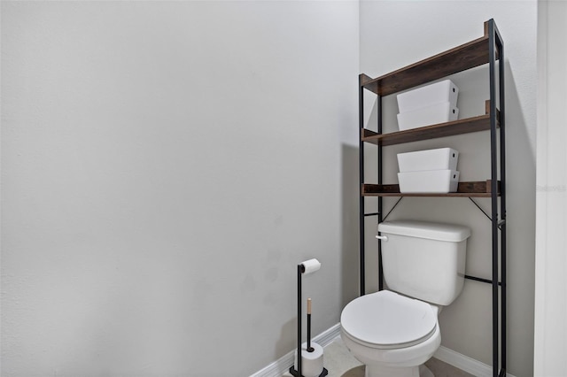 bathroom with baseboards and toilet