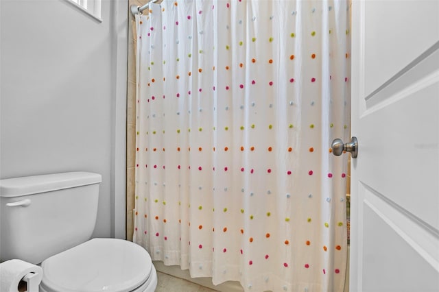 bathroom with curtained shower and toilet