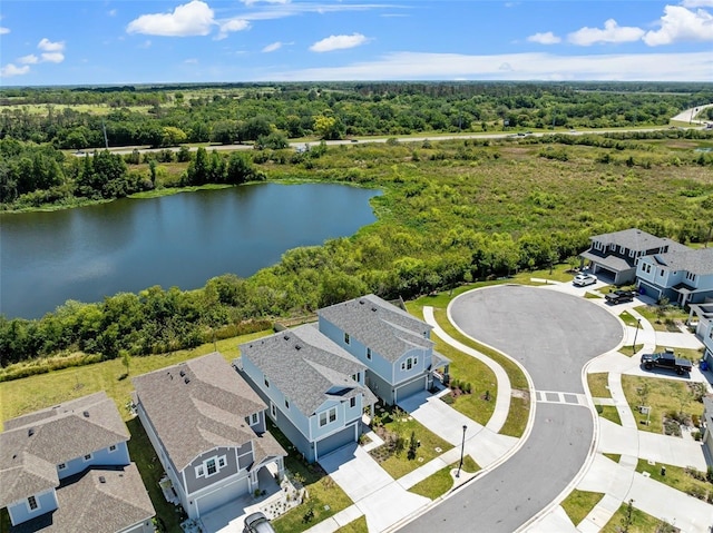 drone / aerial view featuring a water view and a view of trees