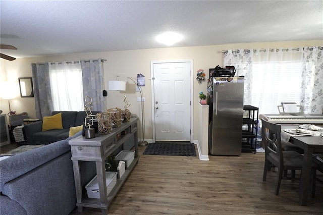 interior space with dark wood-style floors, baseboards, and a ceiling fan