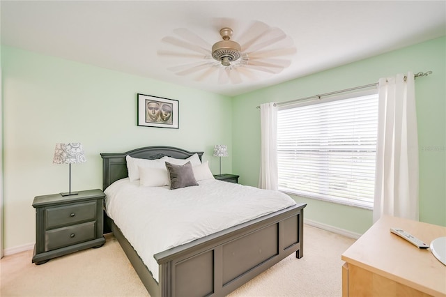 bedroom with light carpet, ceiling fan, and baseboards