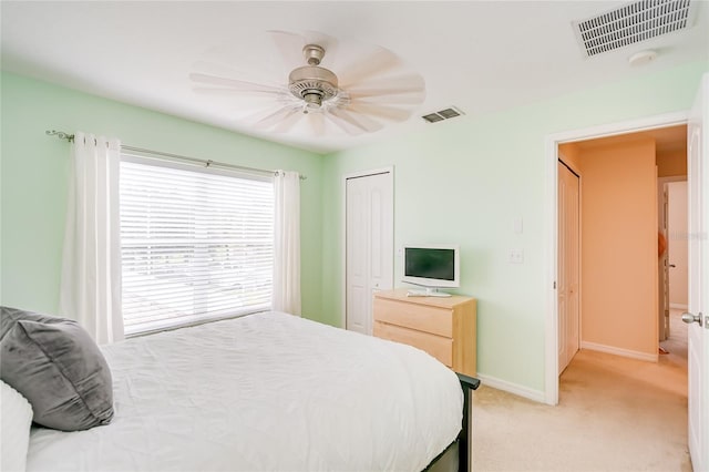 bedroom with light colored carpet, a closet, visible vents, and baseboards