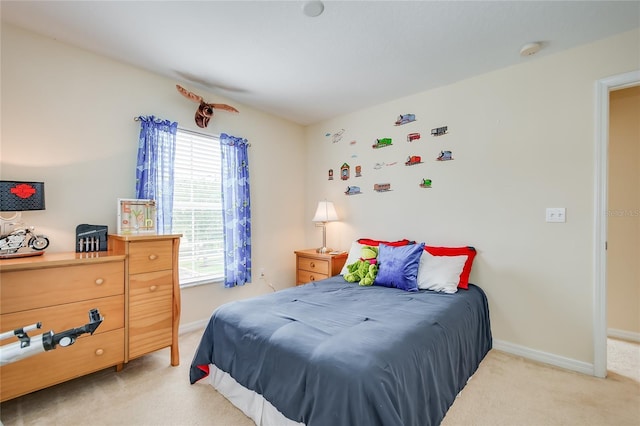 bedroom with light carpet and baseboards