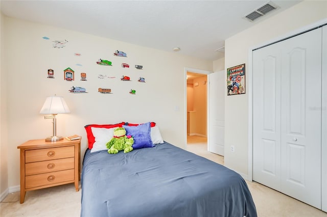 bedroom with baseboards, visible vents, a closet, and light colored carpet