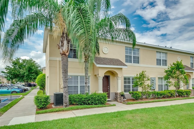 multi unit property with roof with shingles, central AC, and stucco siding