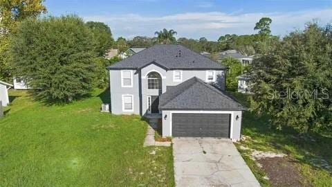 view of front of house with a garage, driveway, and a front lawn