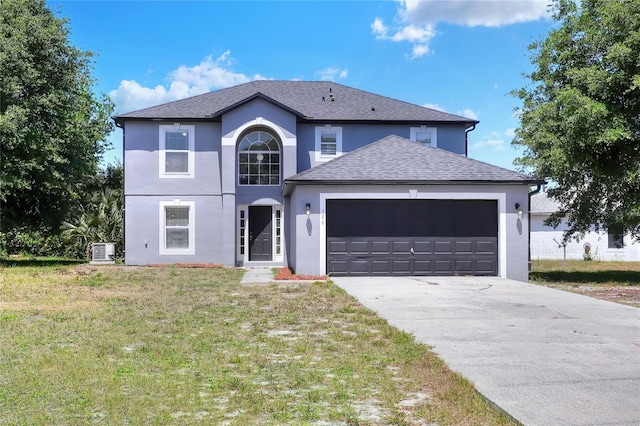 traditional home featuring stucco siding, a front lawn, driveway, and a garage