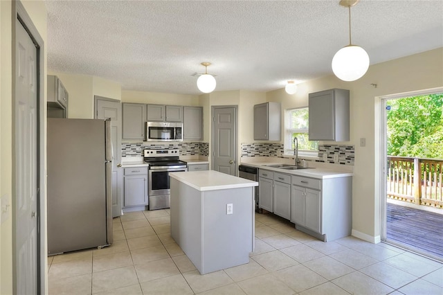 kitchen featuring gray cabinets, appliances with stainless steel finishes, tasteful backsplash, and a sink