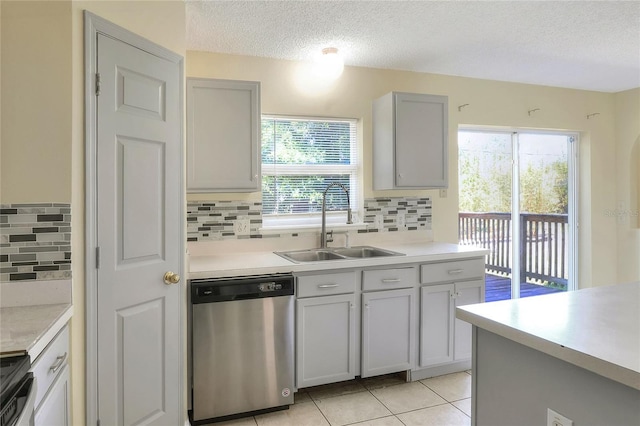 kitchen featuring backsplash, stainless steel appliances, a textured ceiling, and a sink