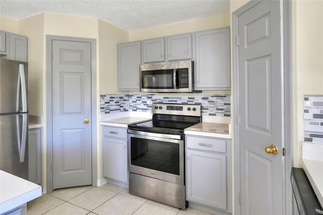 kitchen featuring light countertops, stainless steel appliances, and gray cabinetry
