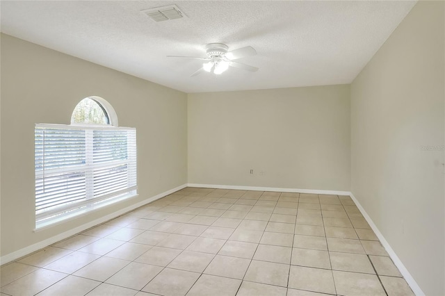 unfurnished room featuring a ceiling fan, visible vents, a textured ceiling, and light tile patterned floors