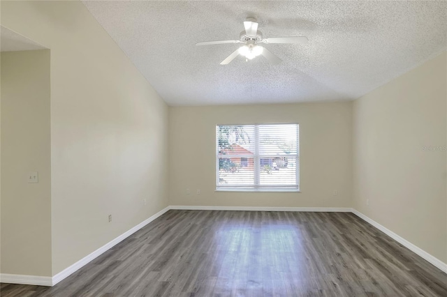 empty room with ceiling fan, baseboards, a textured ceiling, and dark wood-type flooring