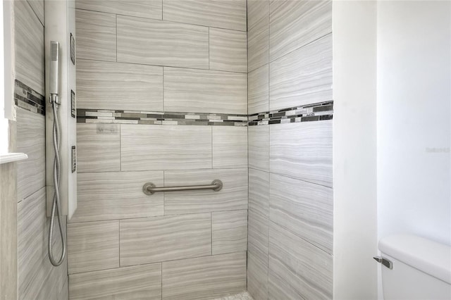 full bath with a tile shower and toilet