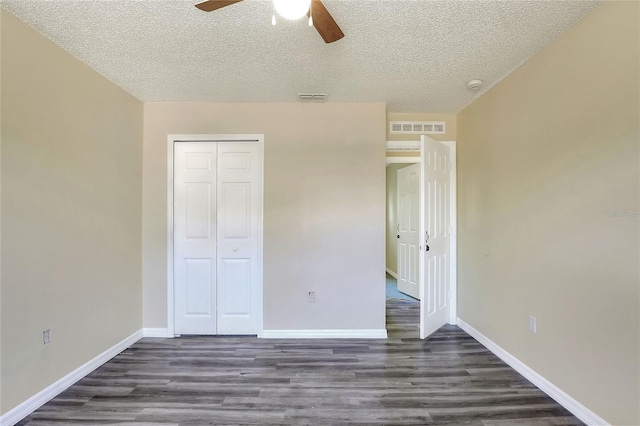 unfurnished bedroom with a closet, wood finished floors, visible vents, and a textured ceiling