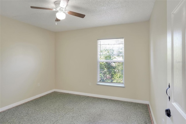 carpeted spare room featuring baseboards, a textured ceiling, and ceiling fan