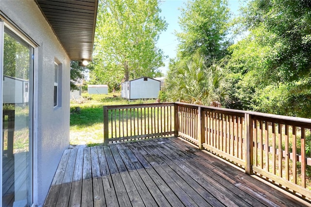 wooden deck featuring an outbuilding and a shed