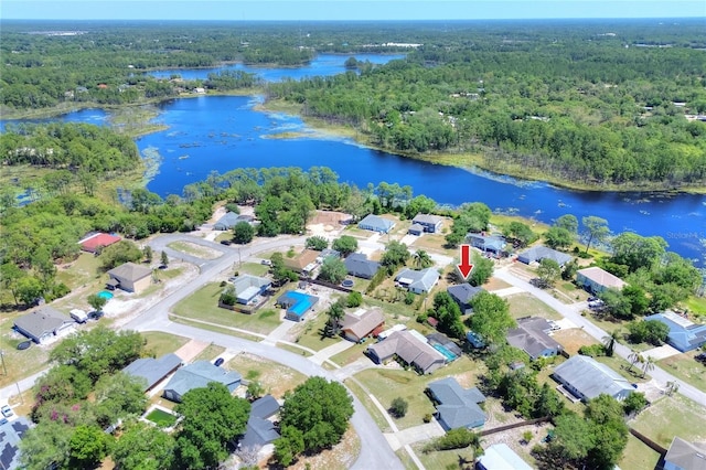 bird's eye view featuring a residential view, a wooded view, and a water view