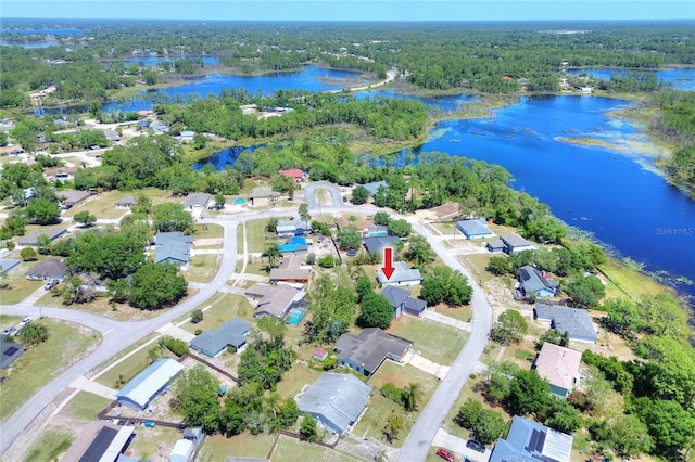 birds eye view of property featuring a forest view, a water view, and a residential view