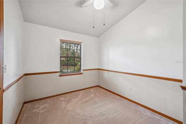 carpeted spare room featuring ceiling fan, a textured ceiling, and lofted ceiling