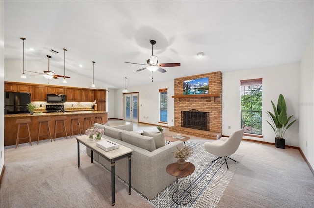 living room with ceiling fan, light carpet, a brick fireplace, and lofted ceiling