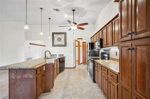 kitchen with sink, backsplash, decorative light fixtures, black appliances, and light stone countertops