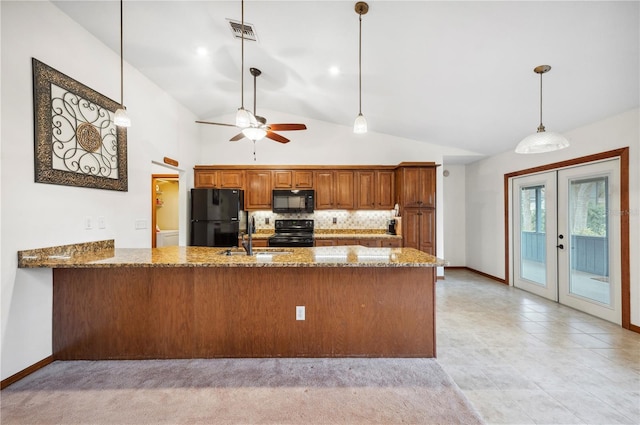 kitchen with kitchen peninsula, decorative light fixtures, black appliances, sink, and stone countertops