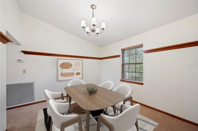 carpeted dining room with lofted ceiling and a chandelier