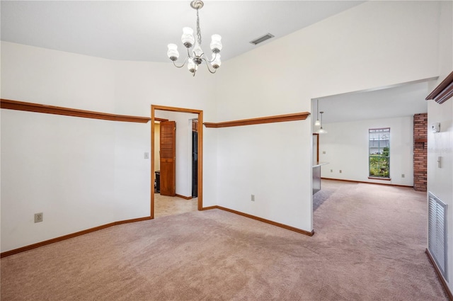 carpeted spare room with high vaulted ceiling and a chandelier