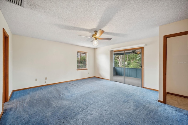 empty room with ceiling fan, carpet floors, and a textured ceiling