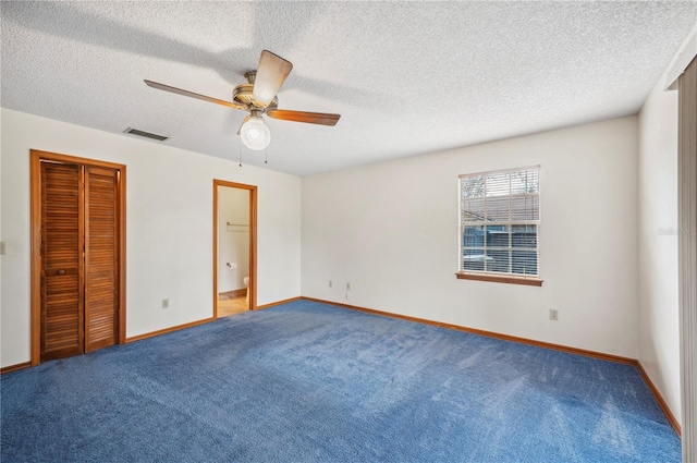 unfurnished bedroom with a closet, a textured ceiling, ceiling fan, carpet floors, and ensuite bathroom