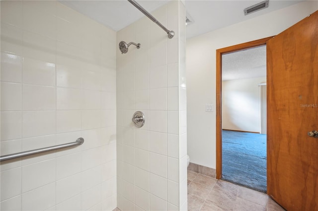 bathroom featuring tiled shower and a textured ceiling