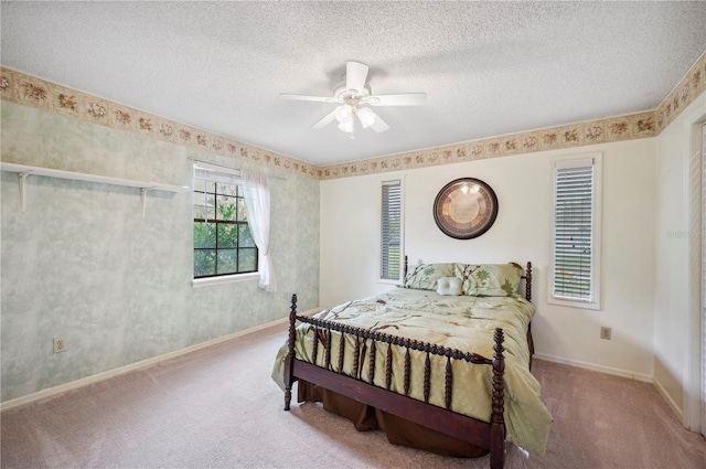 bedroom featuring ceiling fan, light carpet, and a textured ceiling