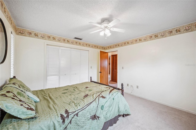 carpeted bedroom featuring a textured ceiling, a closet, and ceiling fan