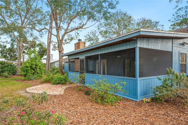 view of side of home featuring a patio and a sunroom