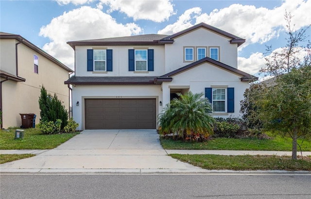 view of front facade featuring driveway, an attached garage, and stucco siding